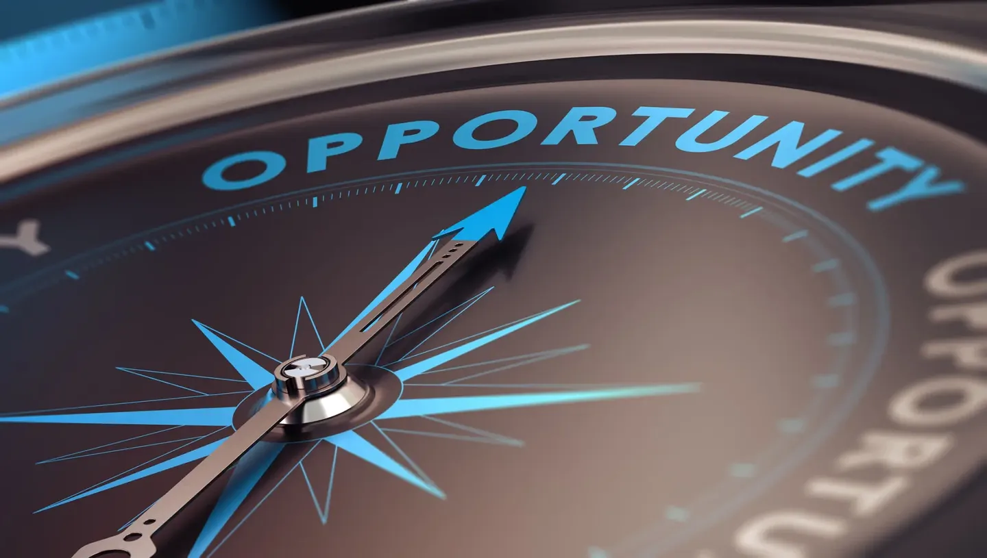 Close-up of a compass needle pointing toward the word 'OPPORTUNITY'.
