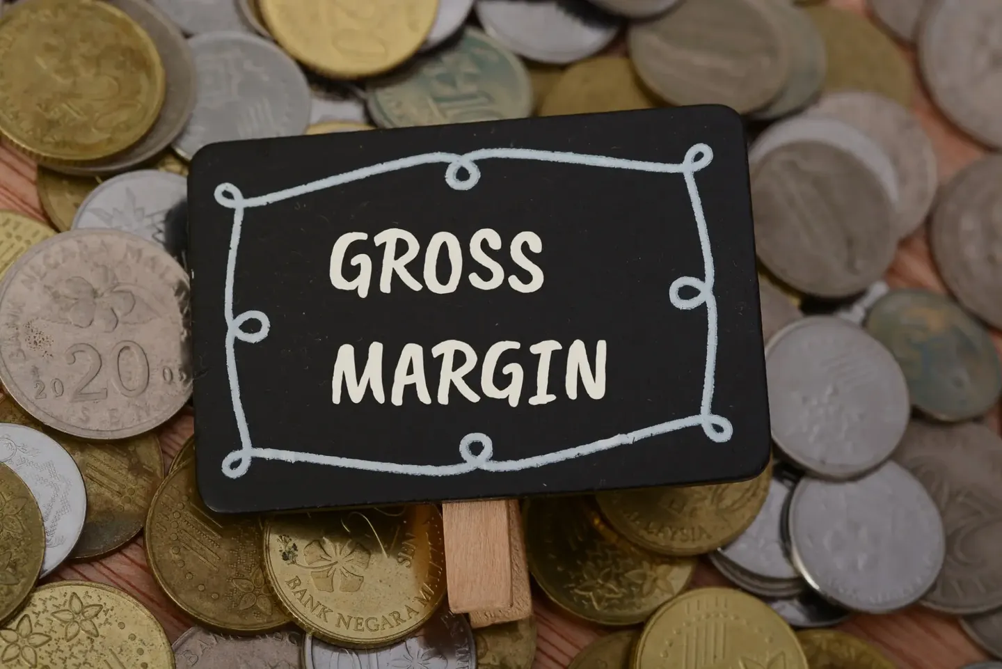 Small sign labeled 'Gross Margin' on coins.