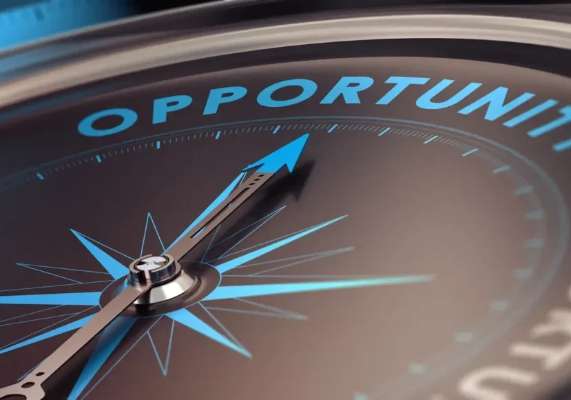 Close-up of a compass needle pointing toward the word 'OPPORTUNITY'.