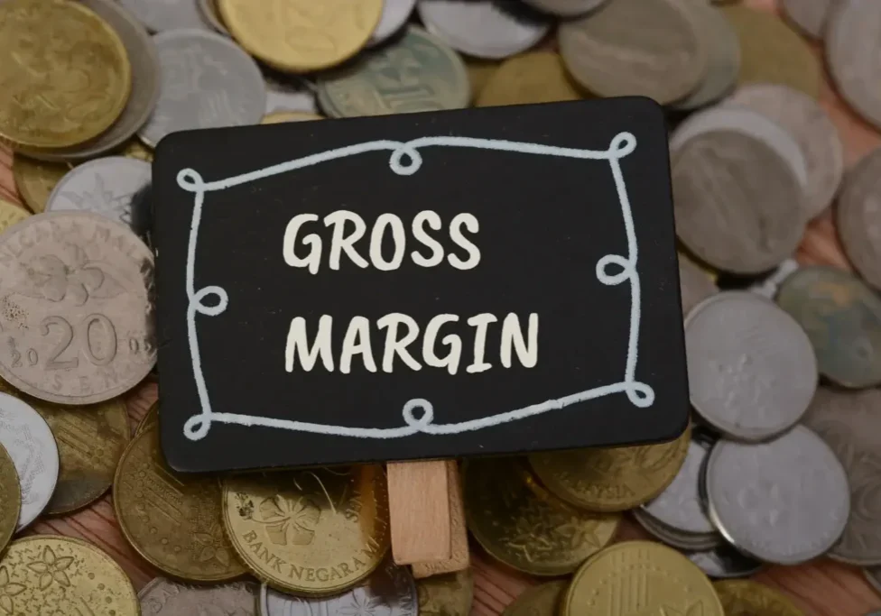 Small sign labeled 'Gross Margin' on coins.