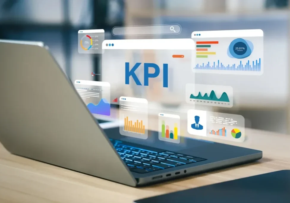 Laptop displaying KPI dashboards and data analytics charts.